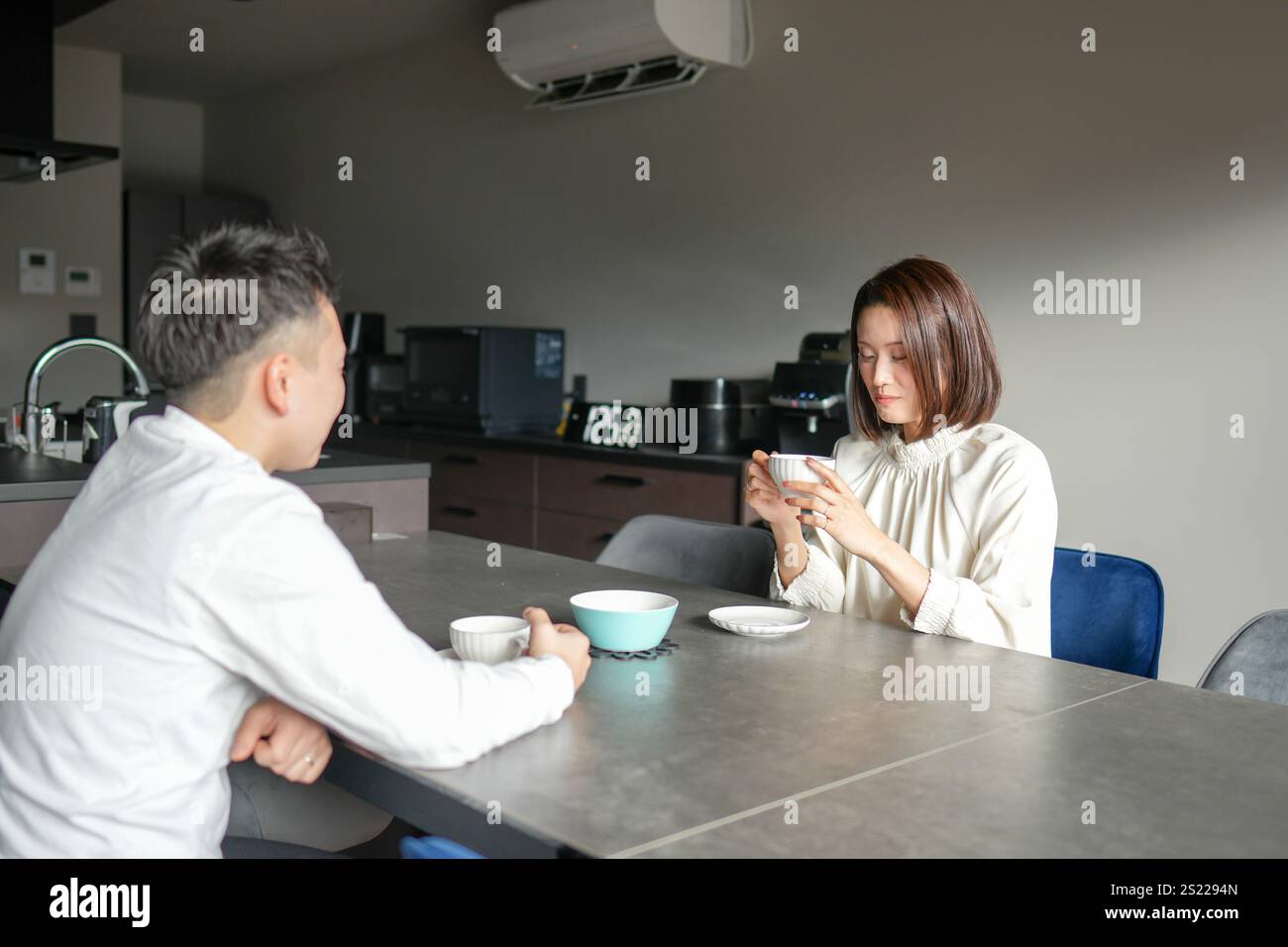 Una coppia giapponese, una donna di 30 anni e un uomo di 20 anni, si godono il tè pomeridiano a casa. Foto Stock