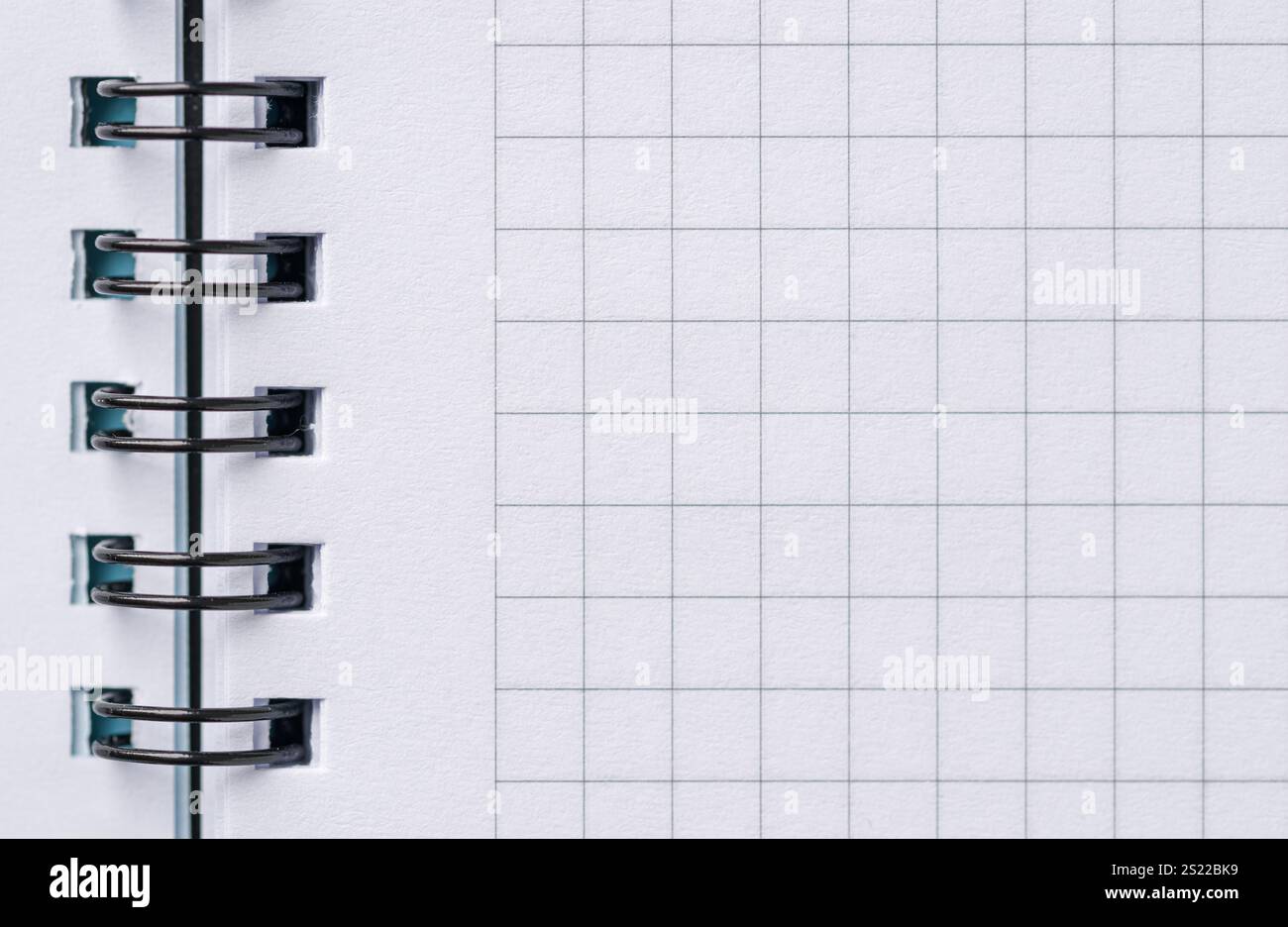 Vista dall'alto della pagina vuota del notebook con spirale nera e quadrati Foto Stock