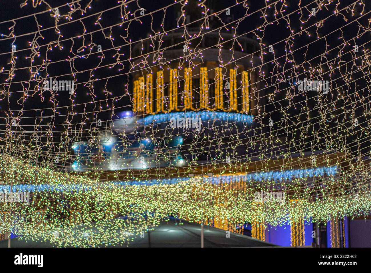 Scena notturna urbana con un edificio moderno adornato da luci LED colorate a. Foto Stock