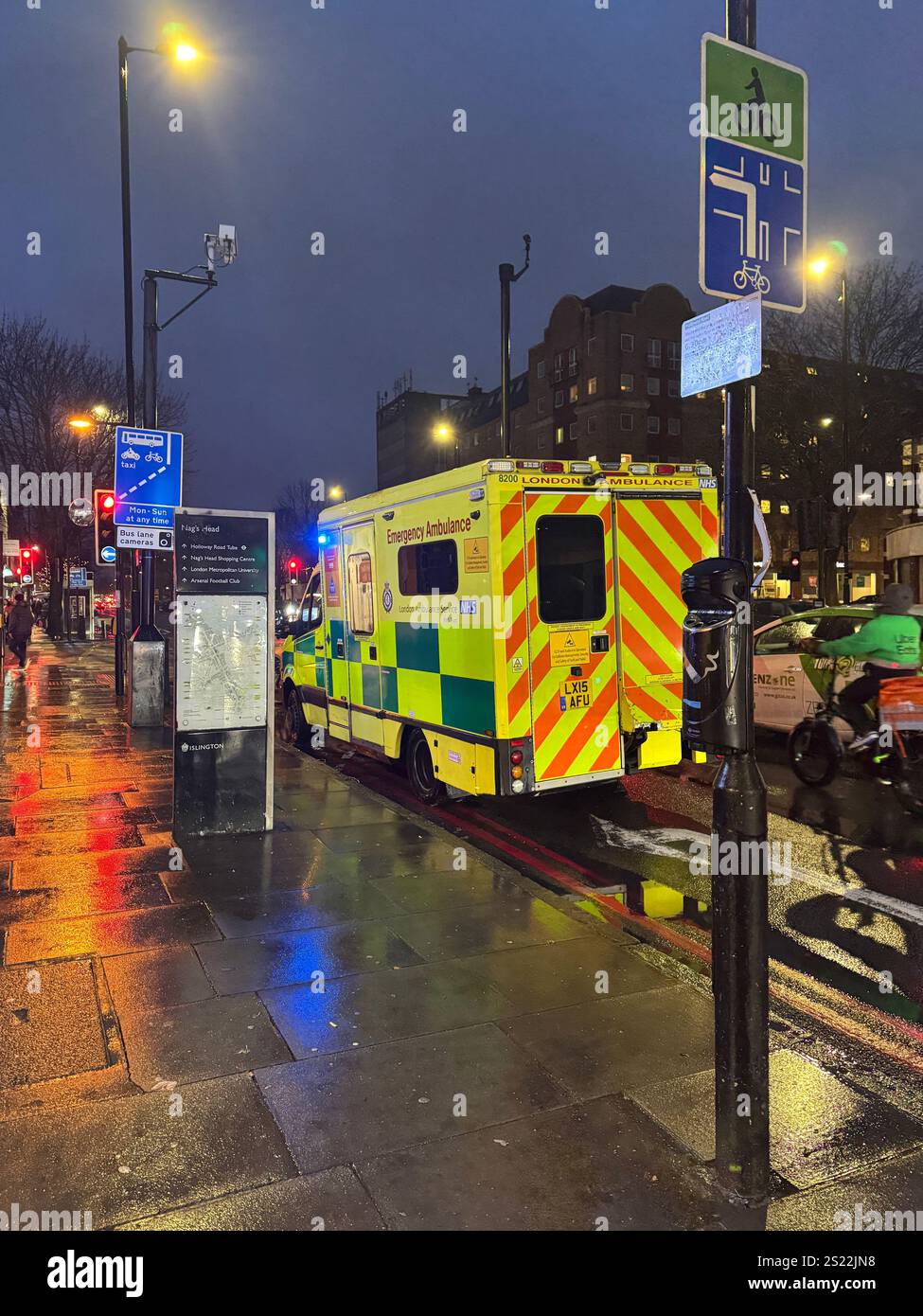 Un'ambulanza parcheggiata sulla Holloway Road, Londra, mentre i paramedici curano un paziente all'interno. Foto Stock