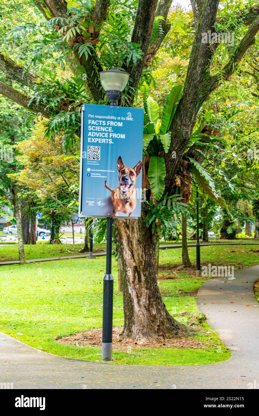 Un cartello su un palo vicino a un parco per cani a Tiong Bahru a Singapore che sensibilizza sulla crudeltà verso i cani facendoli incatenare a lungo termine Foto Stock