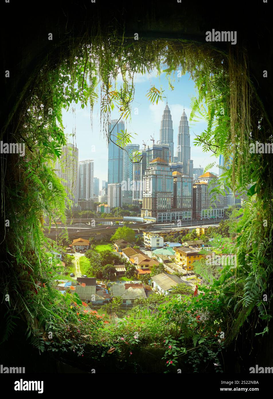 Il paesaggio urbano di Kuala Lumpur è visto attraverso una vibrante cornice naturale, che mostra lo sviluppo urbano in un ambiente tropicale Foto Stock