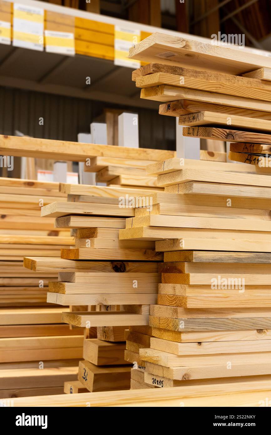 Una sezione legname ben organizzata in un negozio di ferramenta, che espone pile di tavole e tavole in legno, perfetta per progetti edili e fai da te. Foto Stock