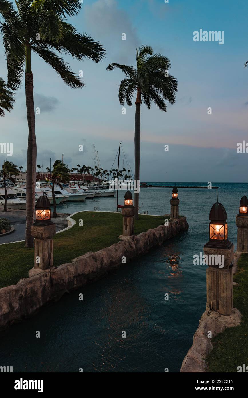 Alla luce del primo mattino, un corso d'acqua che sfocia nella Renaissance Marina o nel porto a est di Oranjestad, Aruba Foto Stock