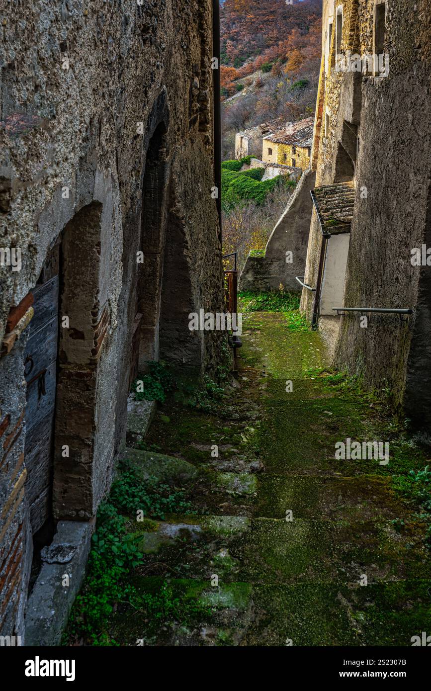 Il vicolo mossy si arrampica tra le vecchie case in pietra in un villaggio medievale italiano in una nuvolosa giornata autunnale. Acciano, provincia dell'Aquila, Abruzzo, Italia, EUR Foto Stock