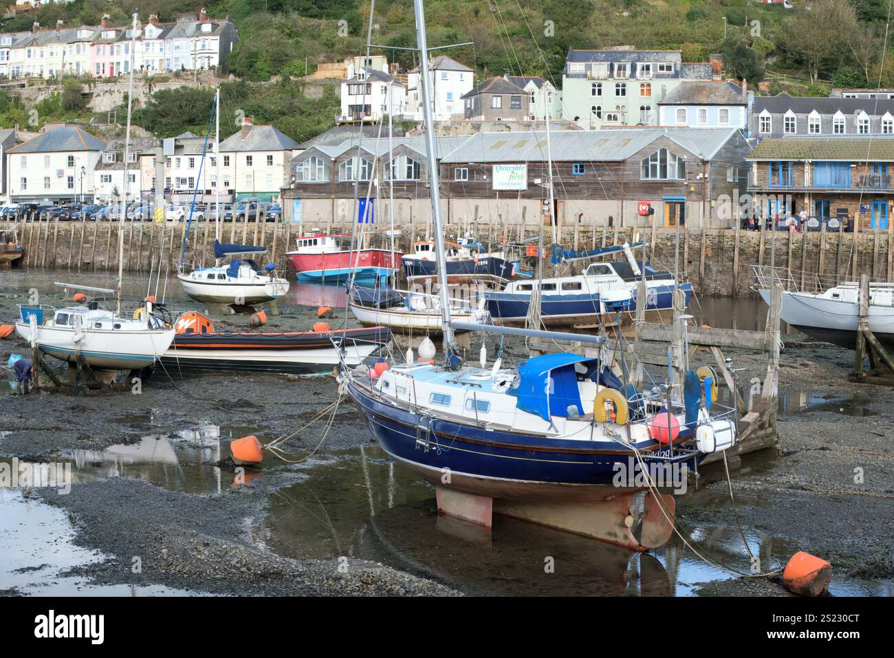 Looe, Cornovaglia, Regno Unito - 25 ottobre 2021: Veduta di yacht e barche ormeggiati nell'East Looe River con la marea fuori e gli edifici sullo sfondo Foto Stock