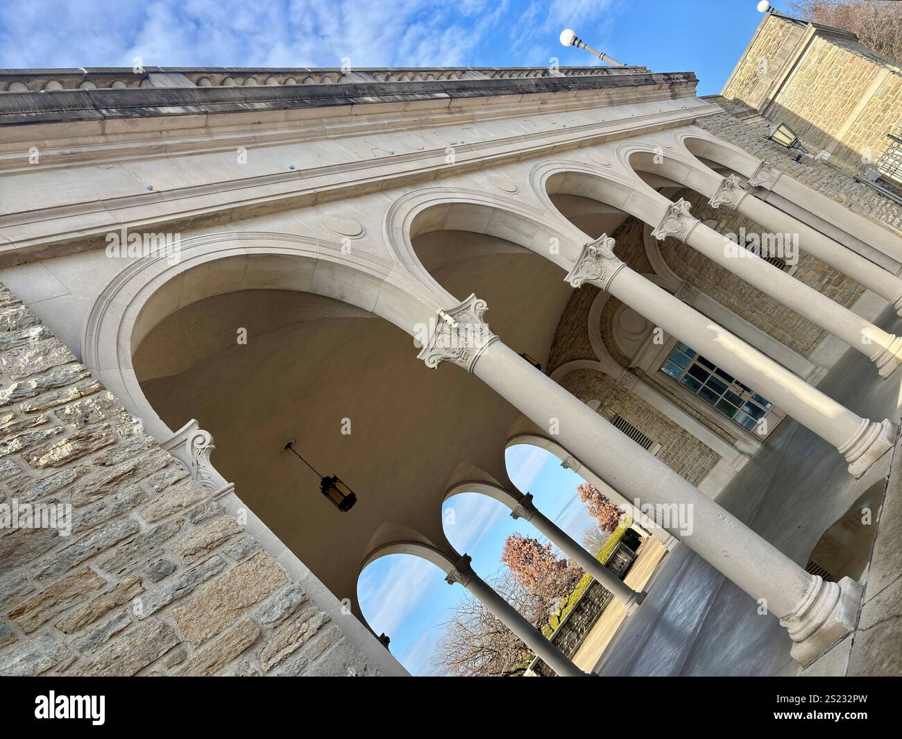Arcata in pietra con colonne e lanterne ornate sotto un cielo azzurro Foto Stock