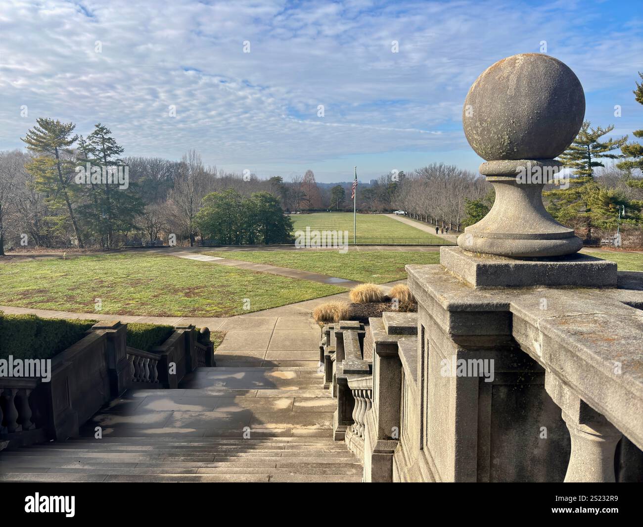 Vista di un parco ben curato con balaustra in pietra in primo piano Foto Stock
