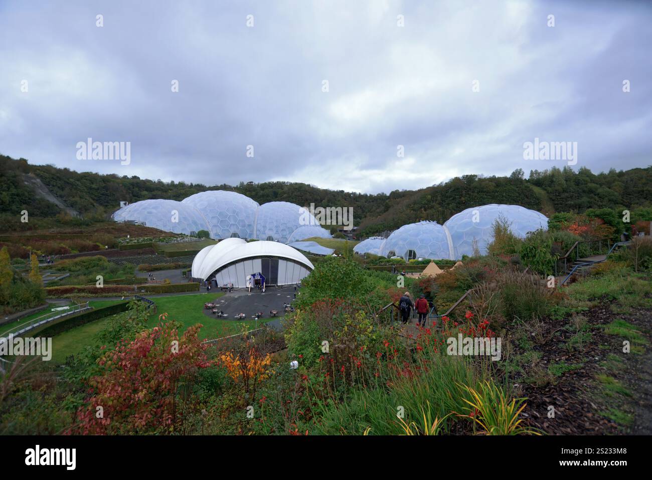 Bodelva, Cornovaglia, Regno Unito - 26 ottobre 2021: Eden Project Biomes e pista di pattinaggio su ghiaccio circondata da ampi giardini all'aperto con molti visitatori visibili e grigi Foto Stock