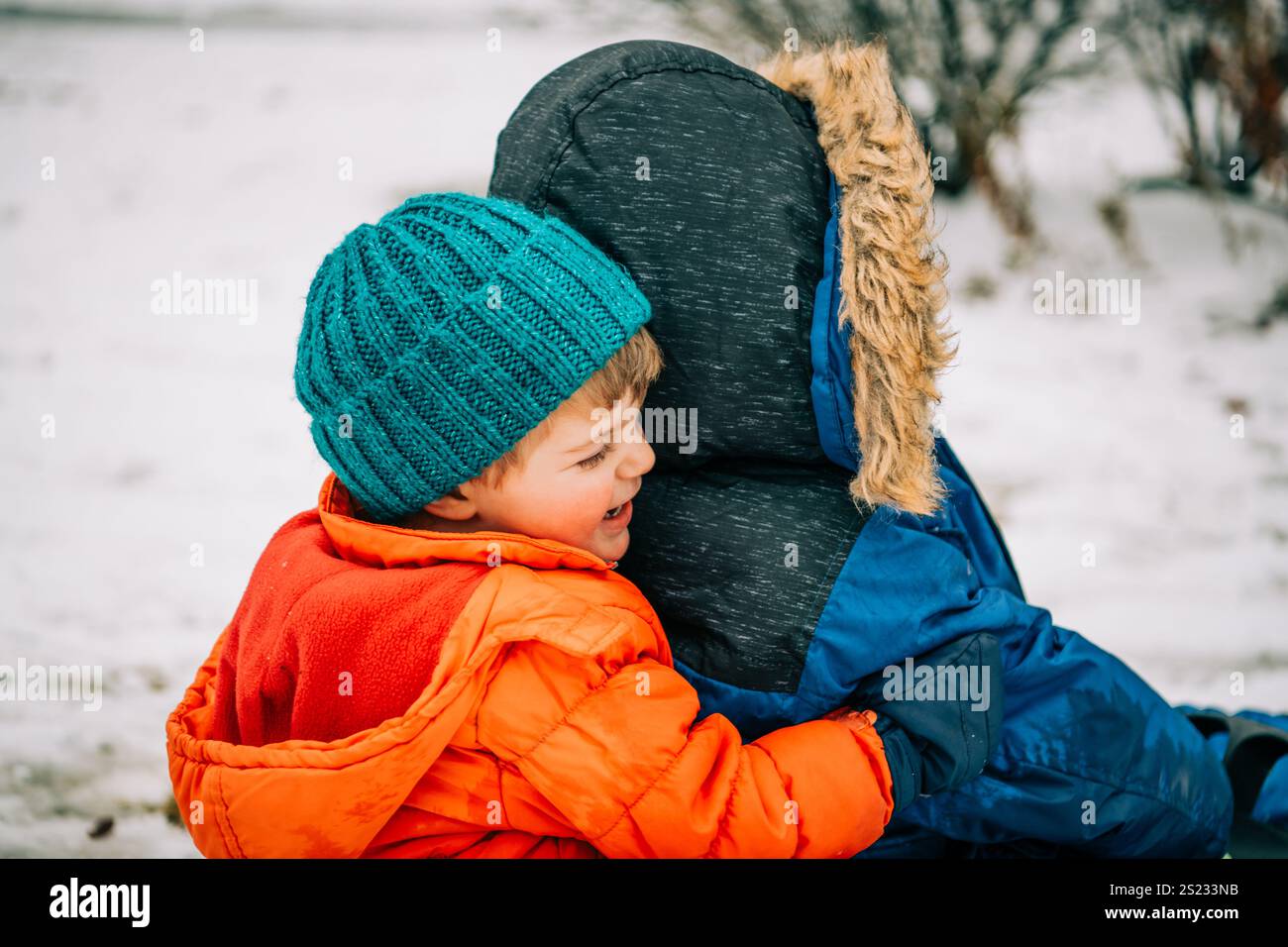 Le coccole invernali portano risate e calore in mezzo alla neve Foto Stock