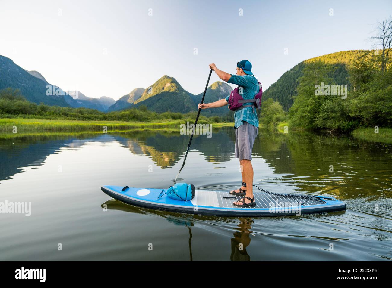 Vista laterale dell'uomo che pagaia su SUP Foto Stock