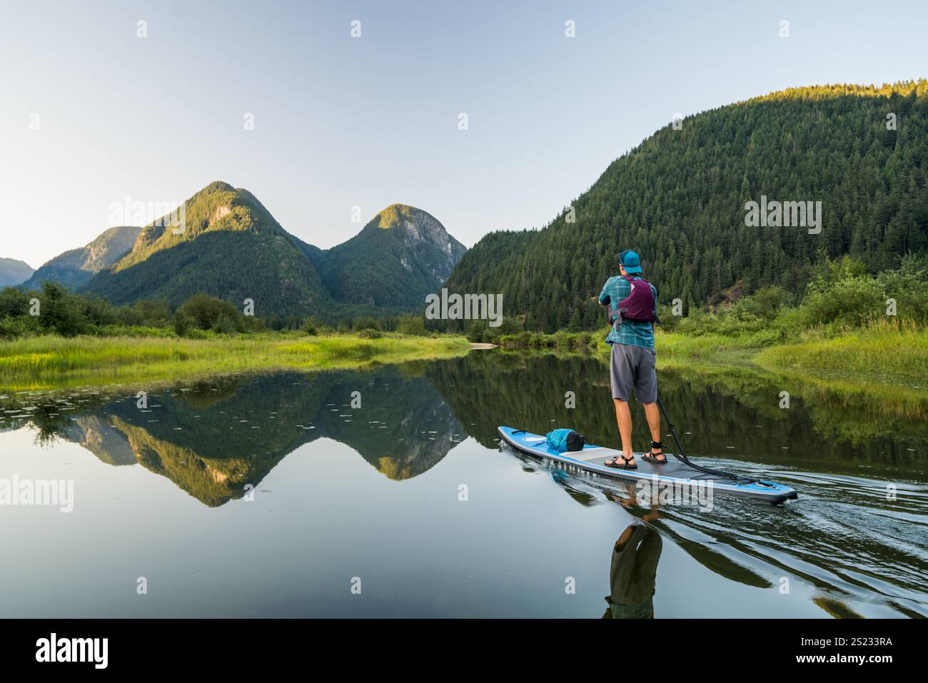 Vista posteriore dell'uomo in piedi sul paddle board nella riserva naturale panoramica Foto Stock
