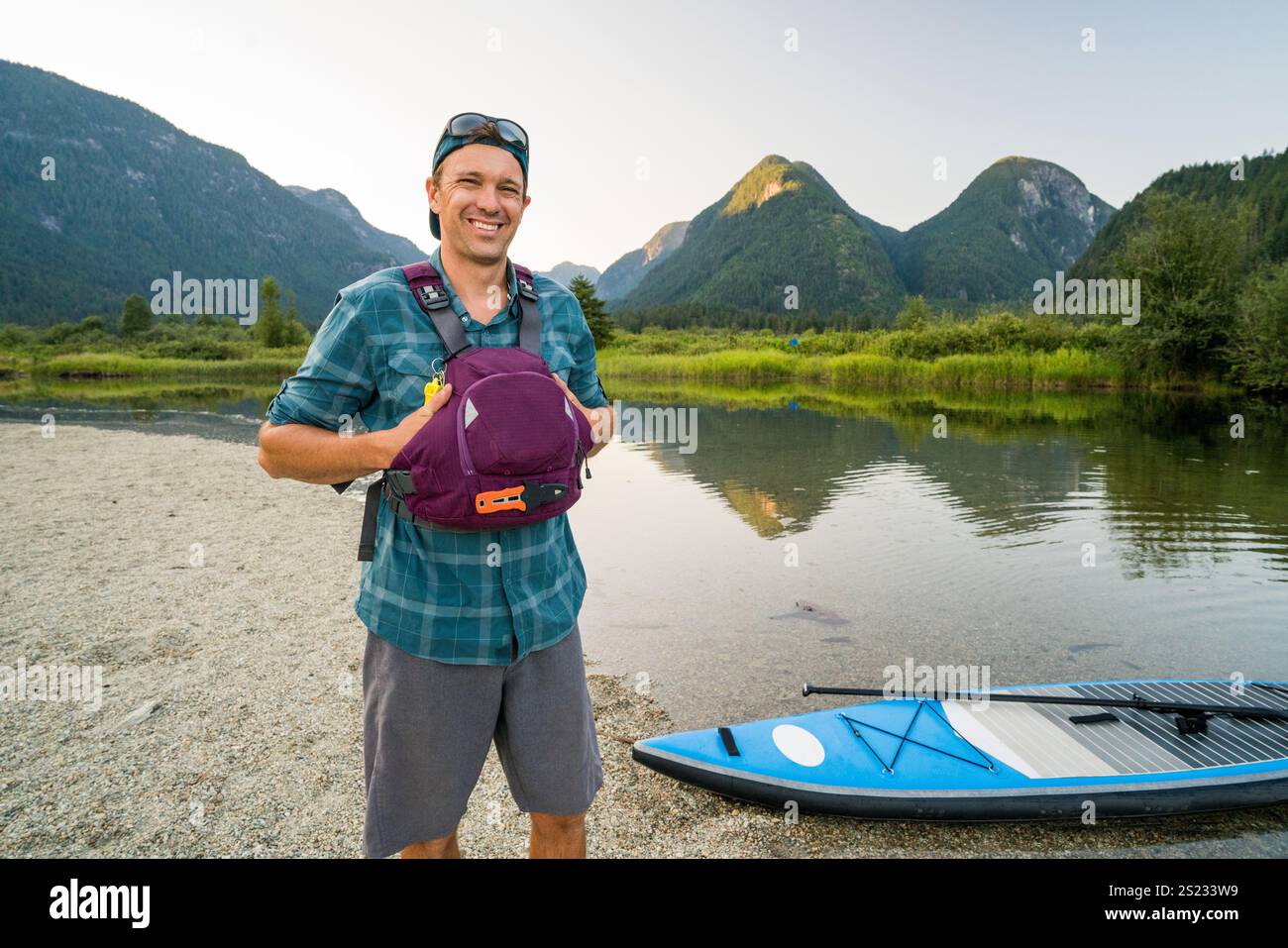 Ritratto di Outdoorsman sano in piedi accanto a SUP Foto Stock
