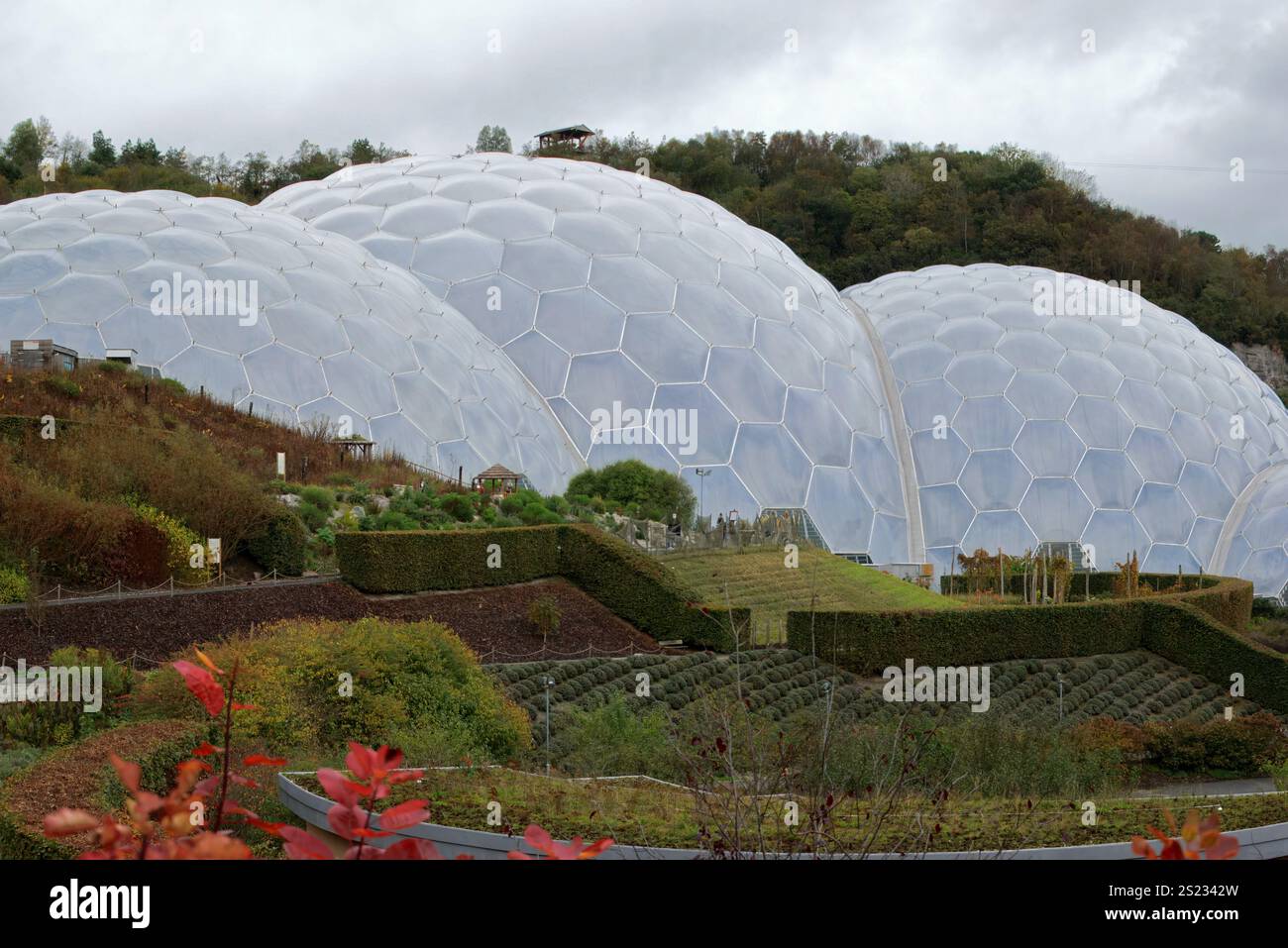 Bodelva, Cornovaglia, Regno Unito - 26 ottobre 2021: Primo piano di Eden Project Biomes con estesi giardini all'aperto in primo piano e cielo coperto grigio Foto Stock