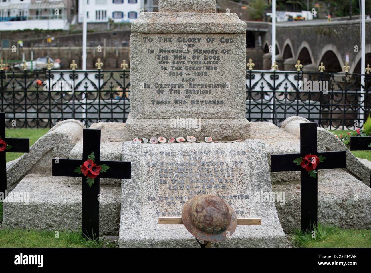 Looe, Cornovaglia, Regno Unito - 22 ottobre 2021: Iscrizione sul monumento alla guerra di pietra agli uomini che morirono combattendo nella prima e seconda guerra mondiale con papaveri e cristiani Foto Stock