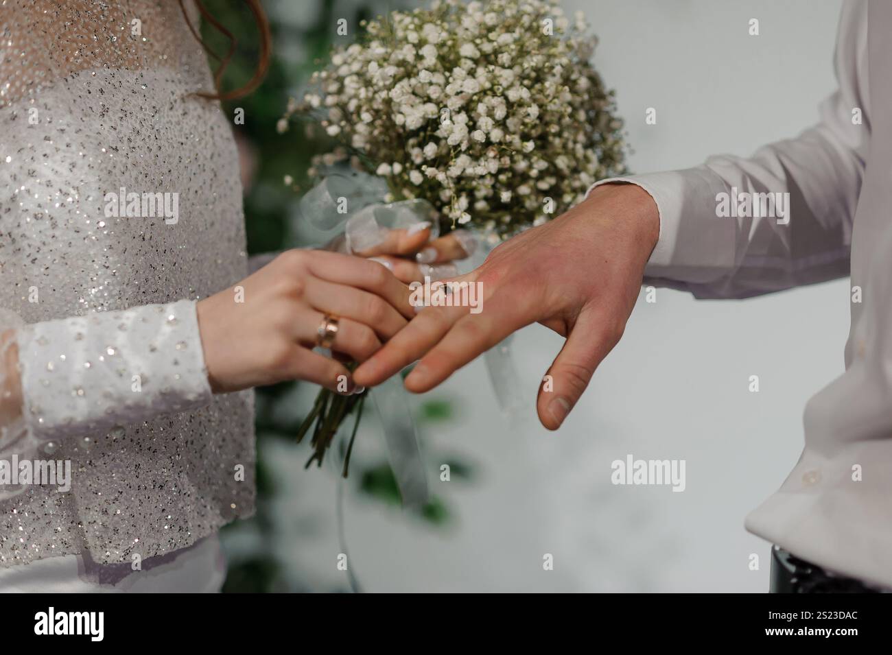 Elegante cerimonia nuziale con scambio di anelli e bouquet delicato. Foto Stock