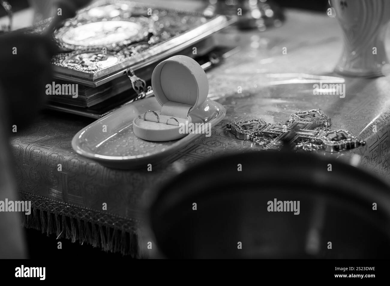 Eleganti dettagli per cerimonie nuziali con anelli e simboli religiosi. Foto Stock