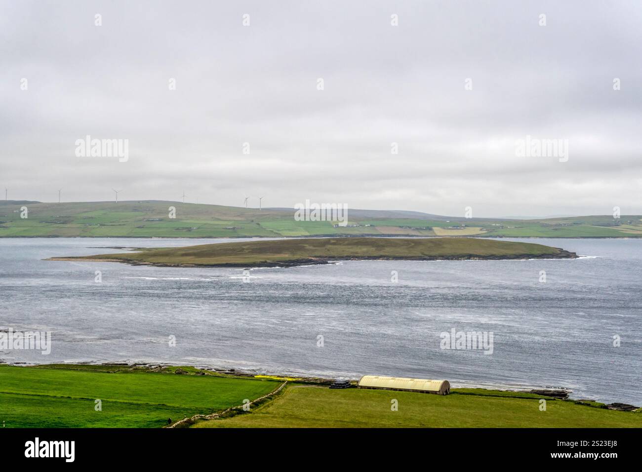 Isola di Eynhallow da Rousay con Mainland Orkney sullo sfondo Foto Stock