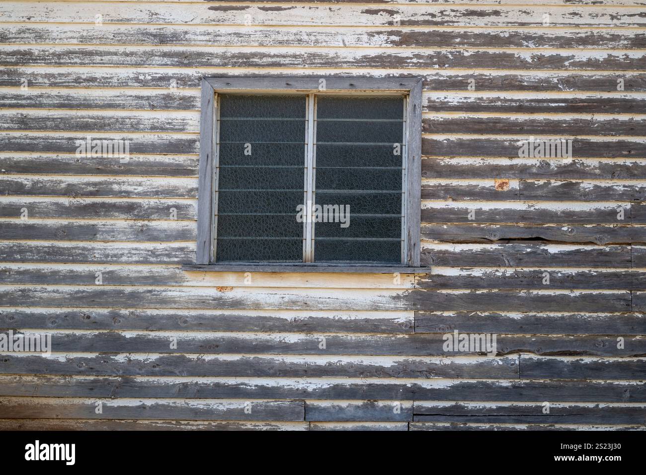 Vecchia casa in legno abbandonata e finestre, sbiadito di vernice, muro di edifici abbandonati, città fantasma Foto Stock