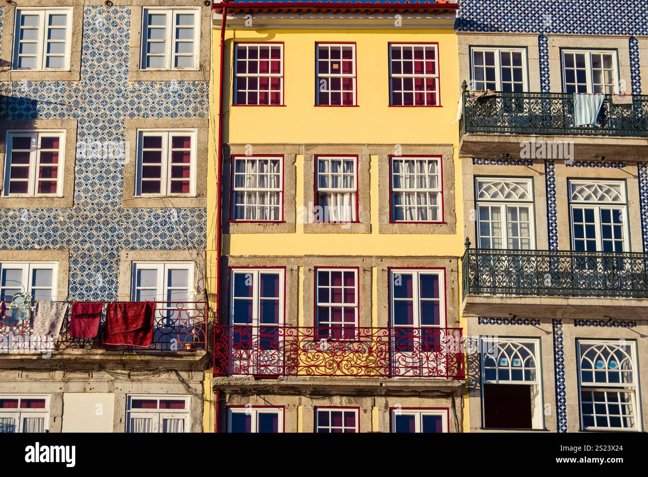 Porto, Portogallo, 25 dicembre 2024: Balconi illuminati dal sole e pareti piastrellate: Il cuore della Ribeira di Porto Foto Stock