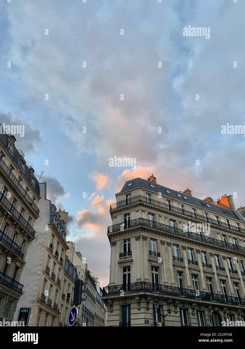 Tramonto parigino con edifici europei d'epoca, nuvole rosa e blu nel cielo. Una splendida miscela di architettura storica e romantiche sfumature serali Foto Stock