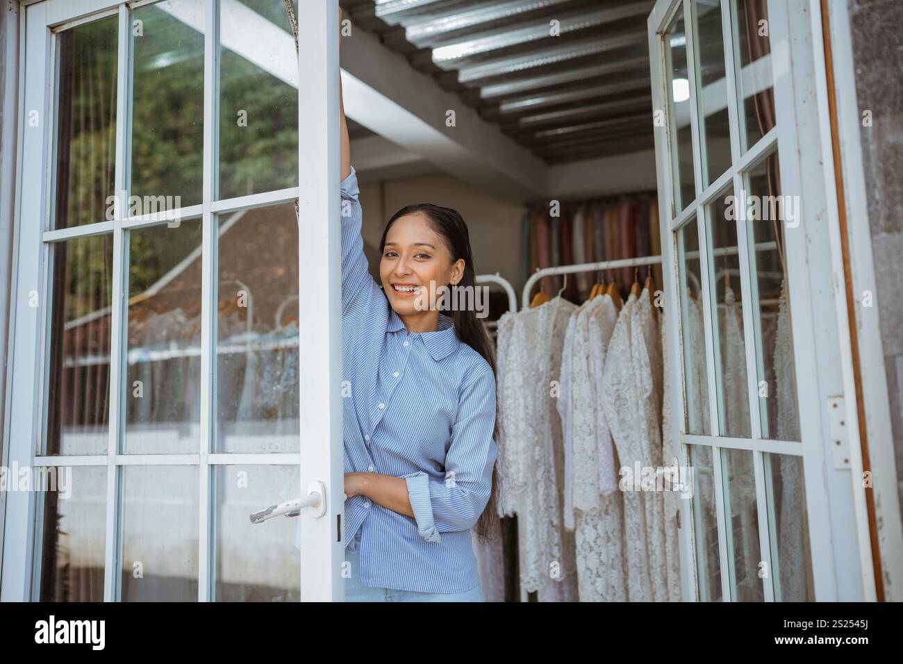 Una donna elegante che posa con grazia in un elegante ambiente d'interni Fashion Boutique Foto Stock