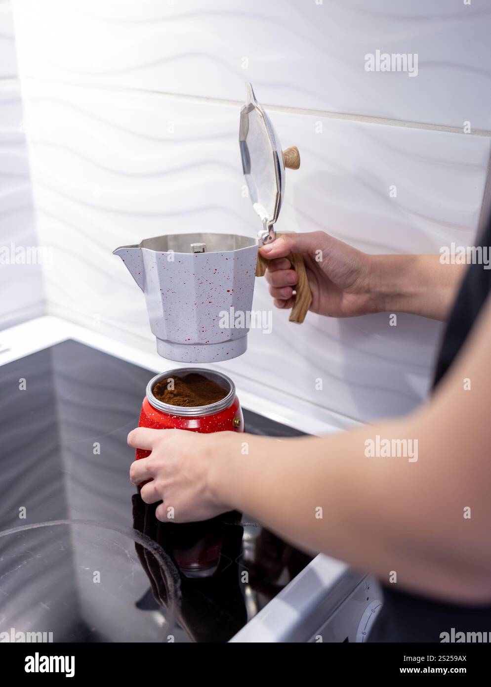 preparare il caffè in una caffettiera su un piano cottura elettrico e il caffè mattutino in una caffettiera Foto Stock