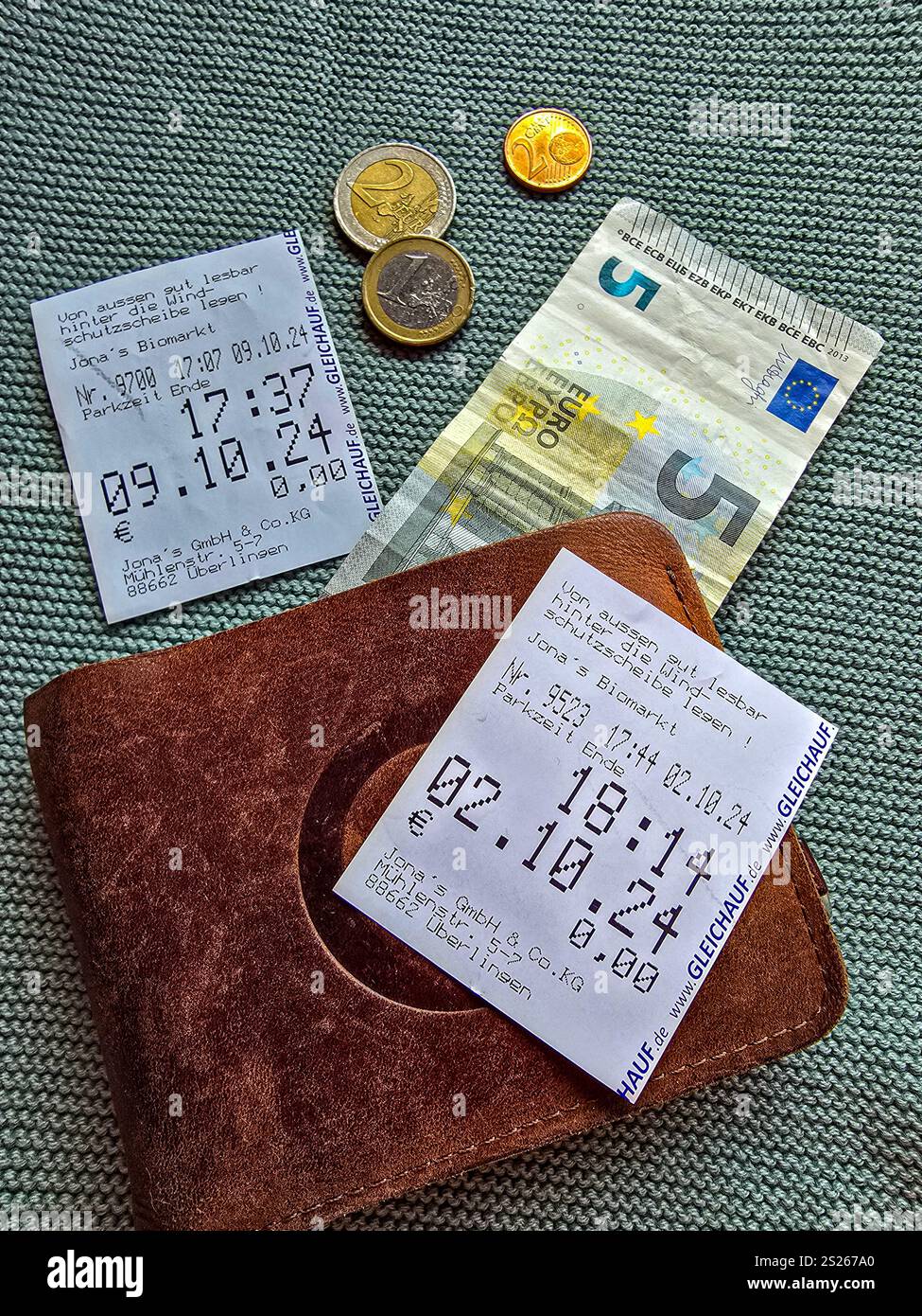 Due assegni per il parcheggio gratuito, portafoglio, banconote in euro e diverse monete. Parcheggio gratuito sul lago di Costanza a Ueberlingen. 9 ottobre 2024. Ueberlingen, GE Foto Stock