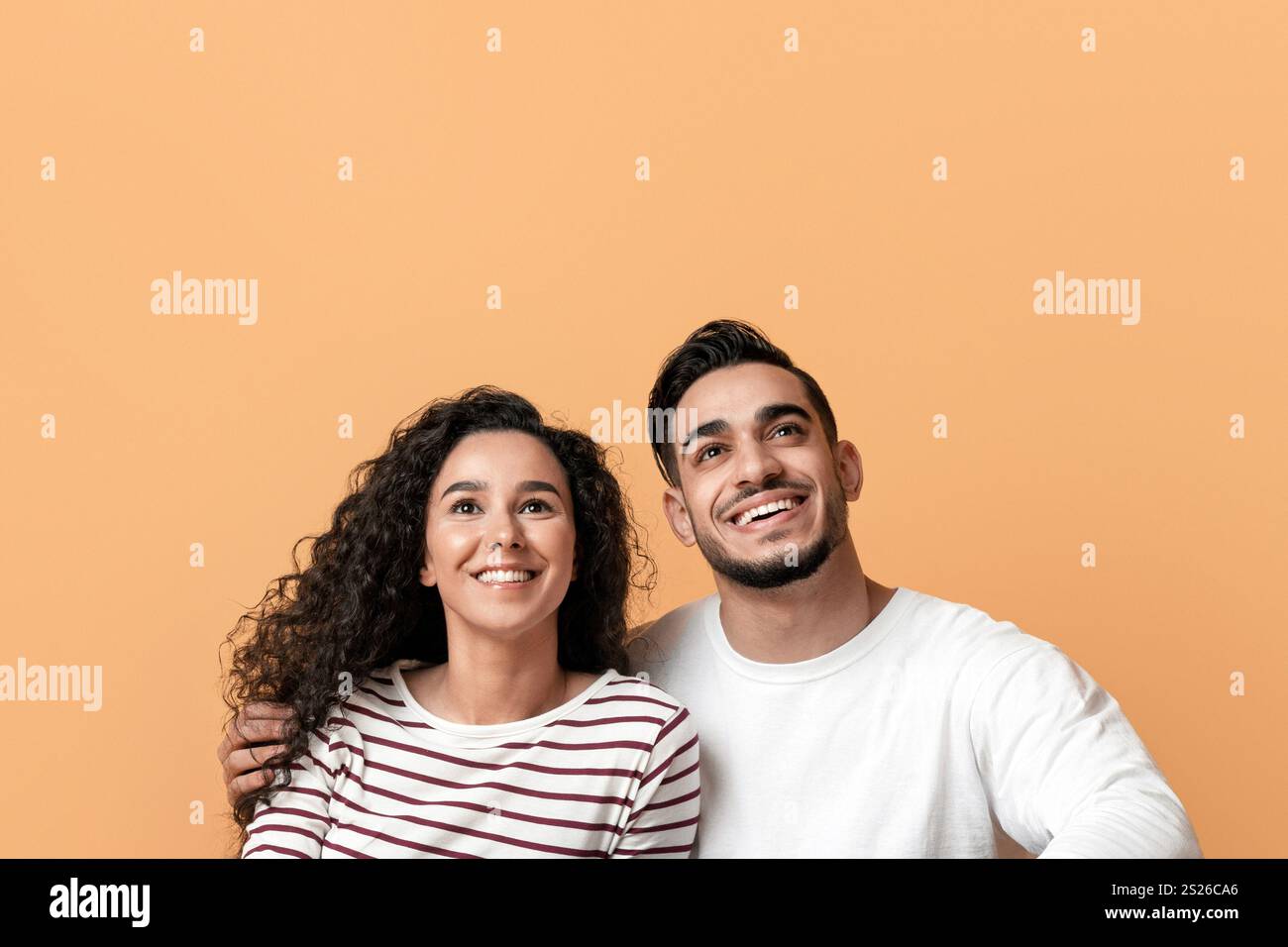 Coppia giovane araba sognante seduta sul pavimento e guardando Copy Space Foto Stock