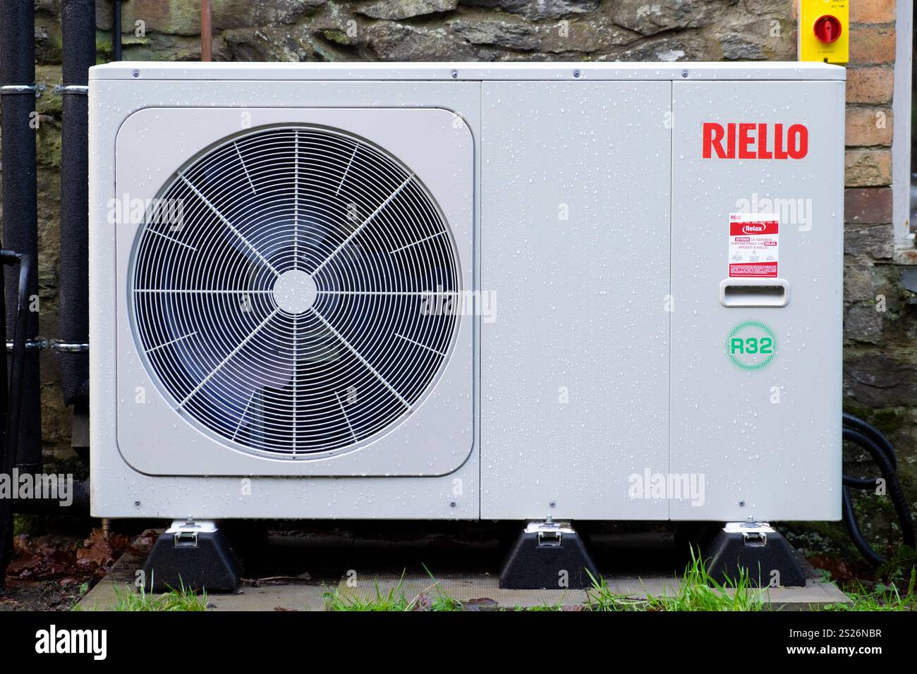 Sistema di riscaldamento a pompa di calore Riello Air Source sulla parete posteriore di un cottage in pietra nel Carmarthenshire Galles Regno Unito Gran Bretagna 2025 KATHY DEWITT Foto Stock