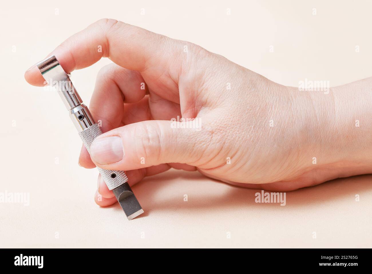 In pelle di strumento di creazione - mano con lama girevole sulla superficie di pelle Foto Stock