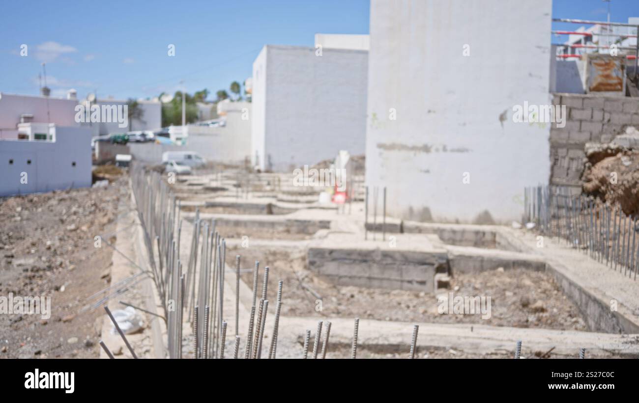 Cantiere sfocato con fondamenta di edifici sfocate e sfondo sfocato che suggerisce lo sviluppo in corso in condizioni di cielo limpido Foto Stock