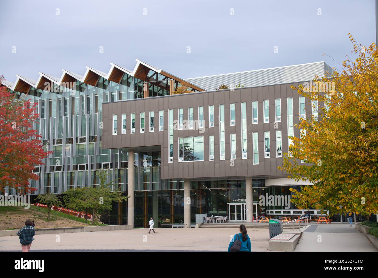 Il nido studentesco AMS dell'Università della British Columbia presenta un'architettura moderna, una facciata in vetro e una piazza aperta circondata da foglie autunnali. Foto Stock