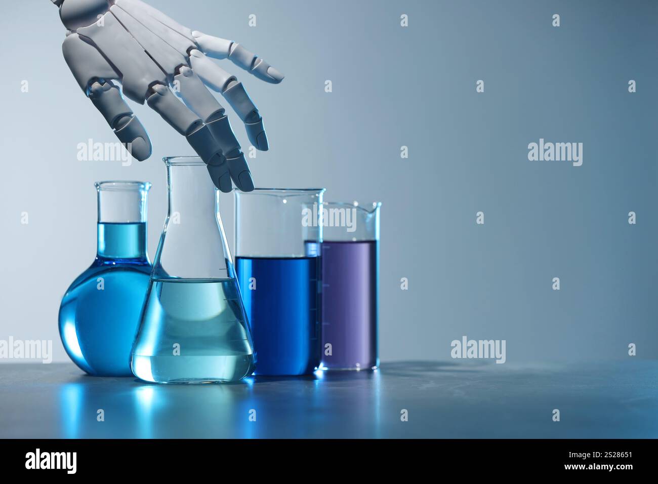 Intelligenza artificiale. Vetreria robot per mani e laboratorio con liquidi sul tavolo su sfondo grigio chiaro, spazio per testo Foto Stock