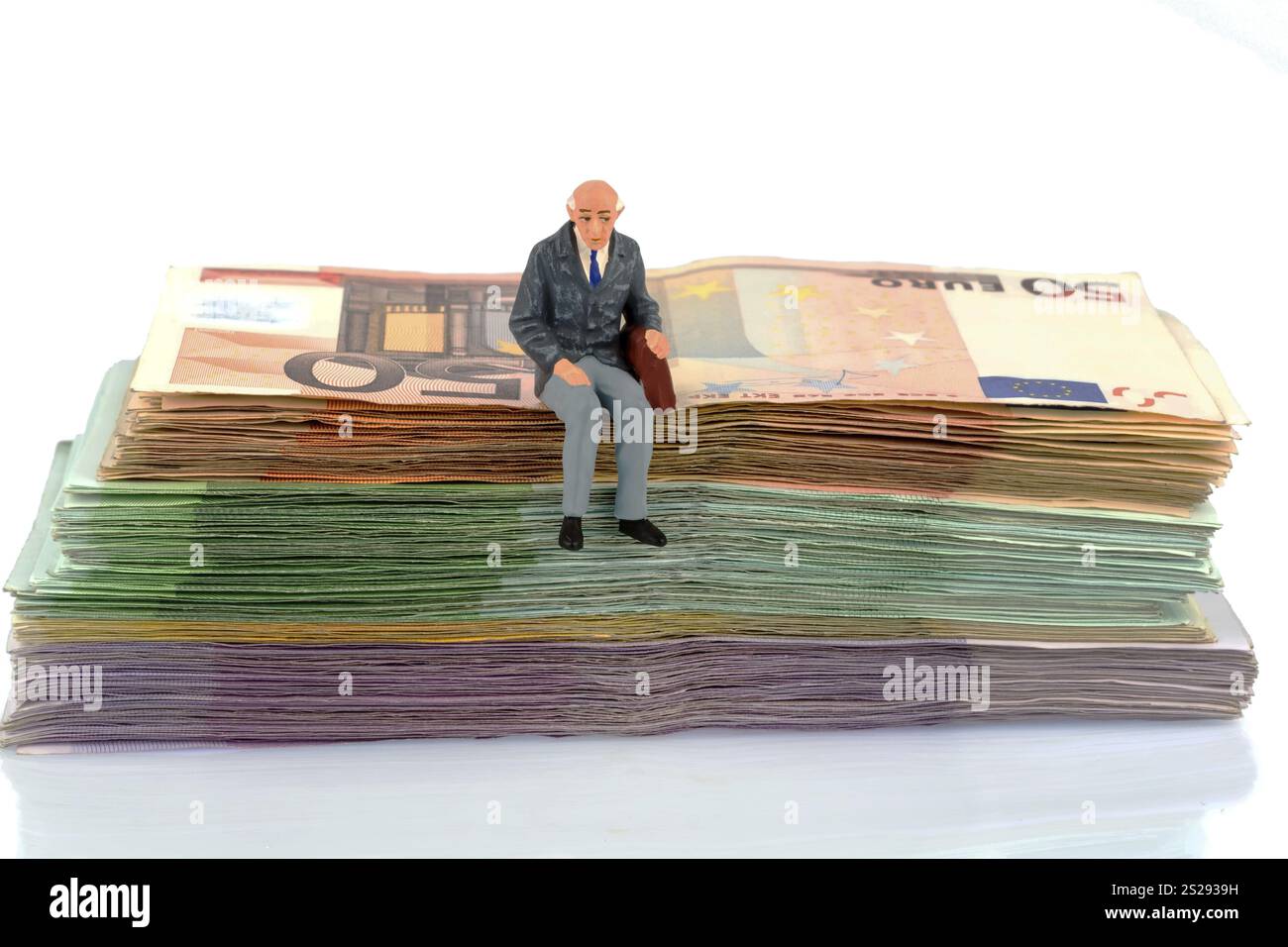 Foto simbolica per il pensionamento e la sicurezza vecchiaia, figura di un vecchio seduto su una pila di banconote Austria Foto Stock