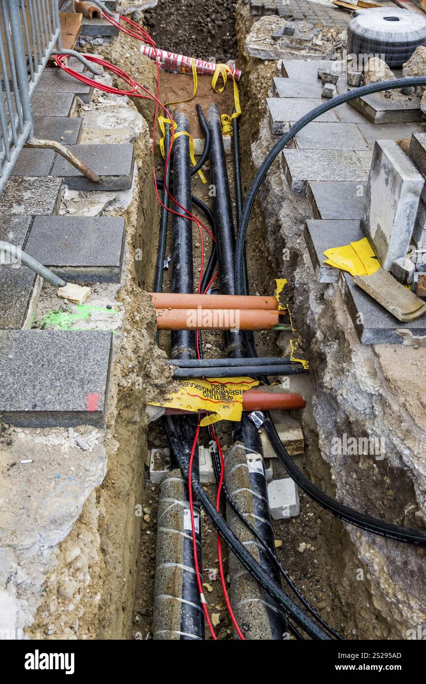 Nuovi tubi per l'acqua, il riscaldamento, il teleriscaldamento e l'elettricità sono in fase di posa in cantiere. Pozzo di scavo con linee di rifornimento Austria Foto Stock