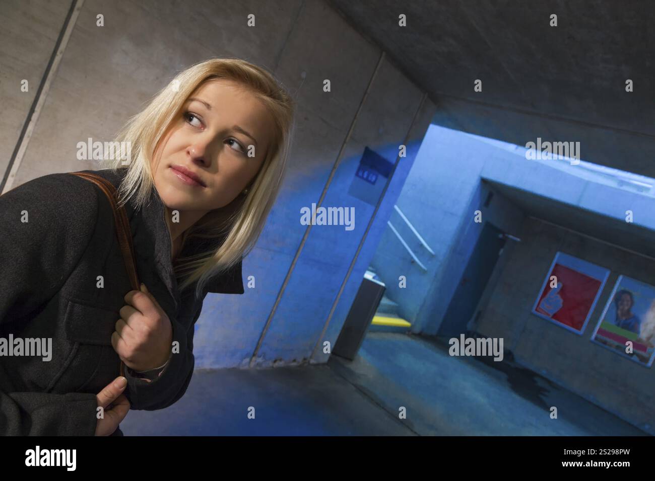 Una giovane donna in una metropolitana pedonale ha paura di molestie e crimini Foto Stock