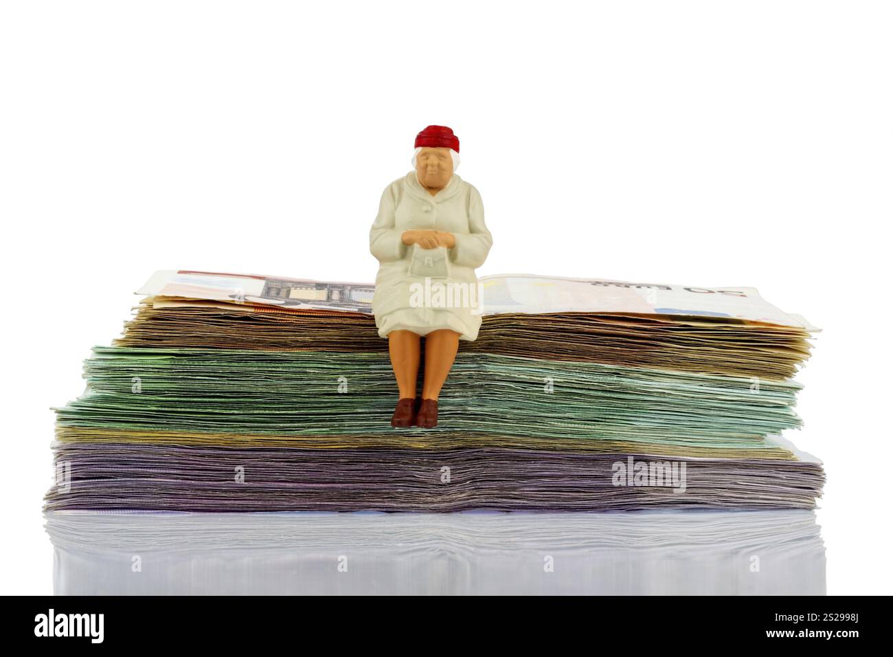 Figura di una donna anziana seduta su un mucchio di banconote, che simboleggia l'assicurazione pensionistica e il pensionamento dell'Austria Foto Stock