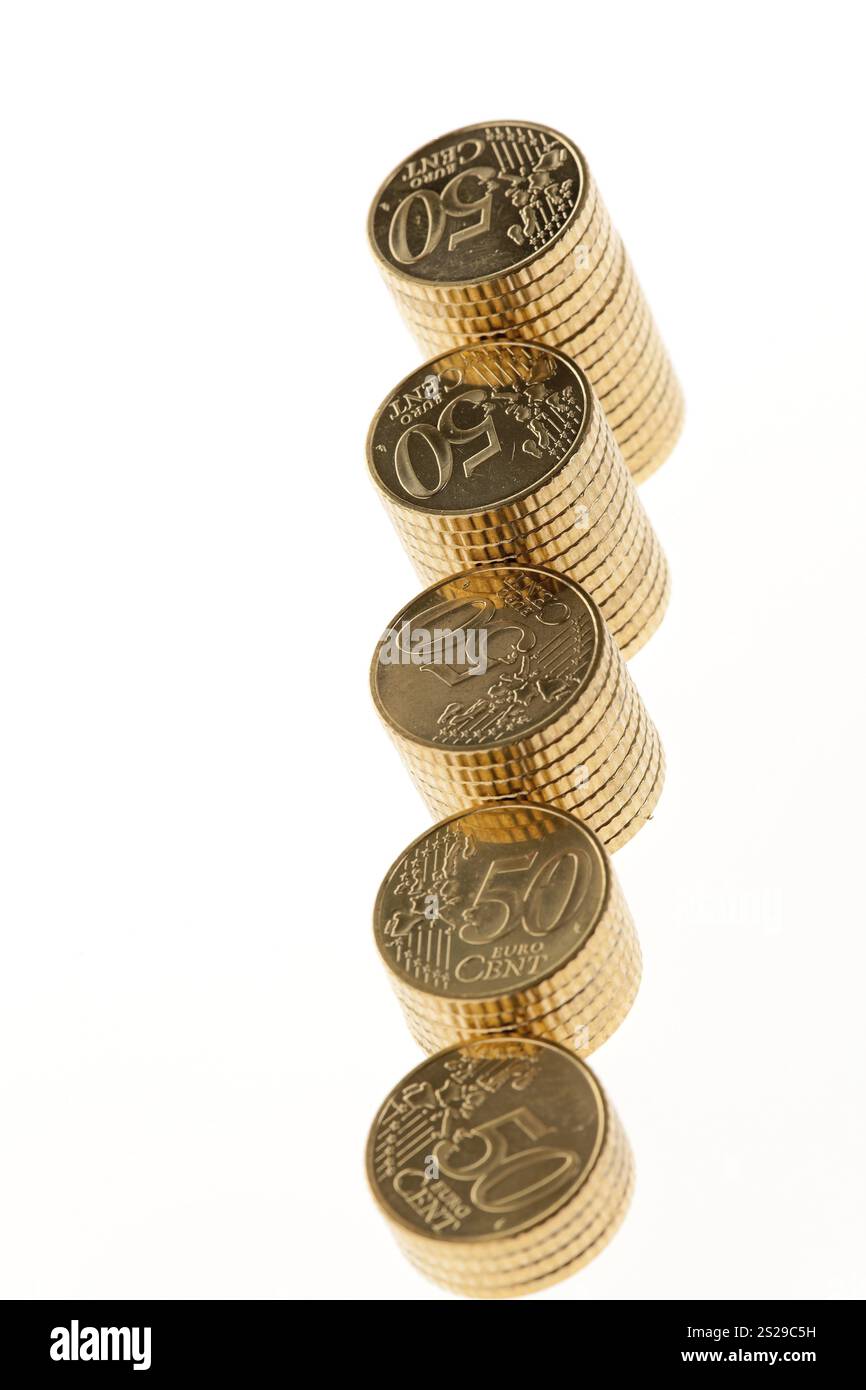 Alcune pile di monete in euro su sfondo bianco Foto Stock