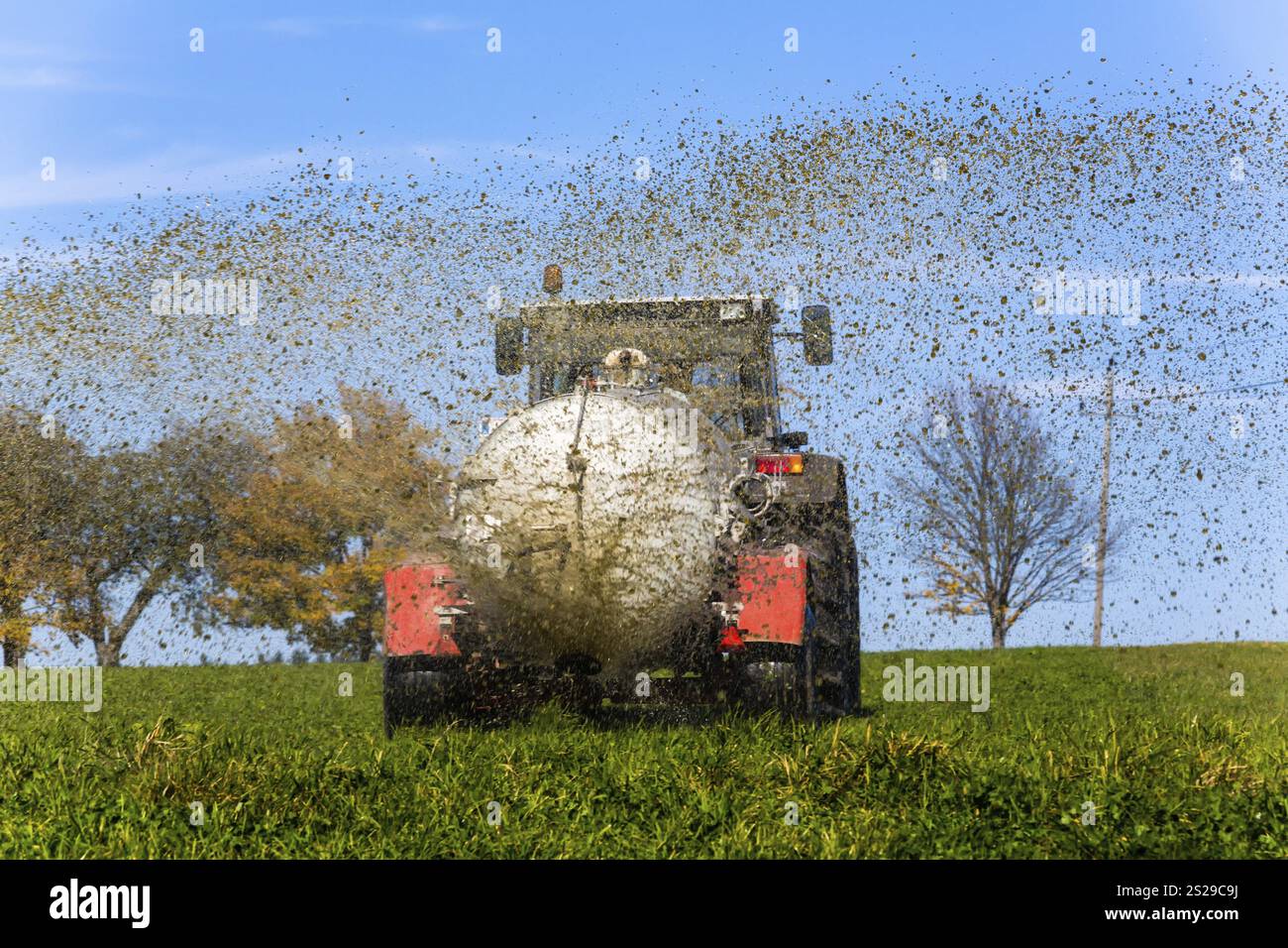 Un trattore fertilizza un campo con concime liquido in autunno in Austria Foto Stock