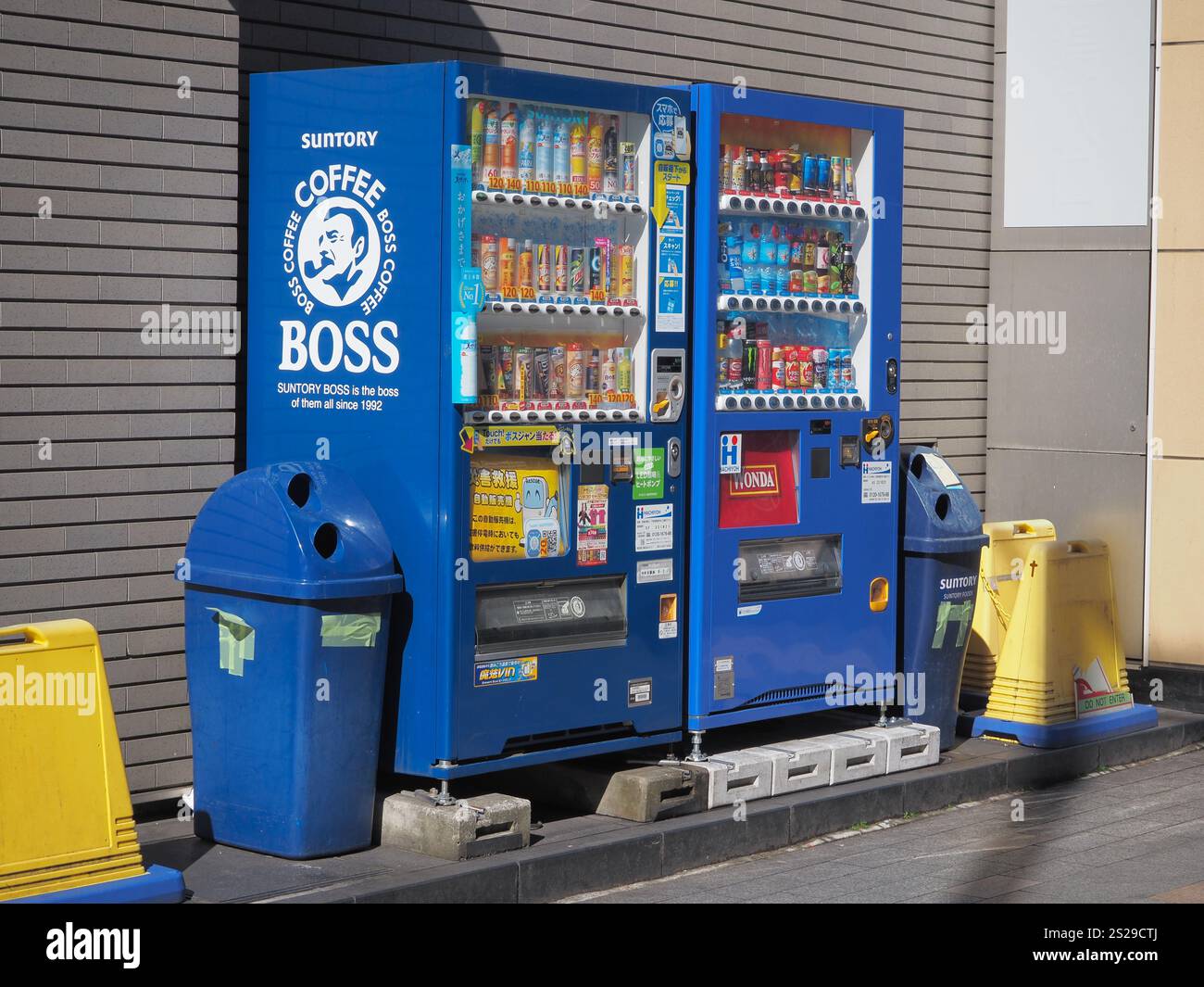 Distributori automatici di bevande con bevande calde e fredde in una strada nel centro di Tokyo. Uno ha il logo Boss Coffee, l'altro un Wonda. Foto Stock