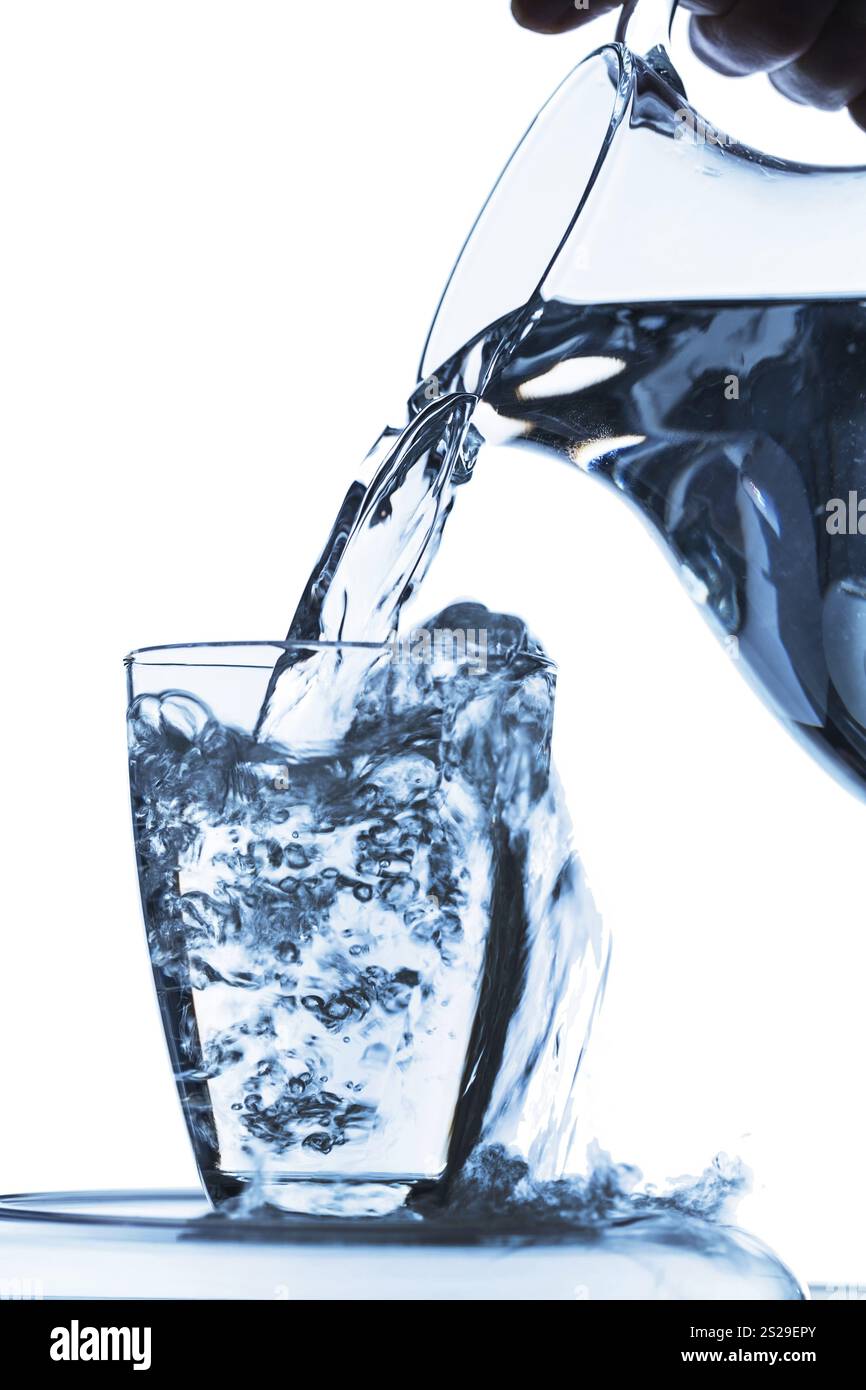 L'acqua pura viene svuotata in un bicchiere da acqua da una caraffa. Acqua potabile fresca Austria Foto Stock
