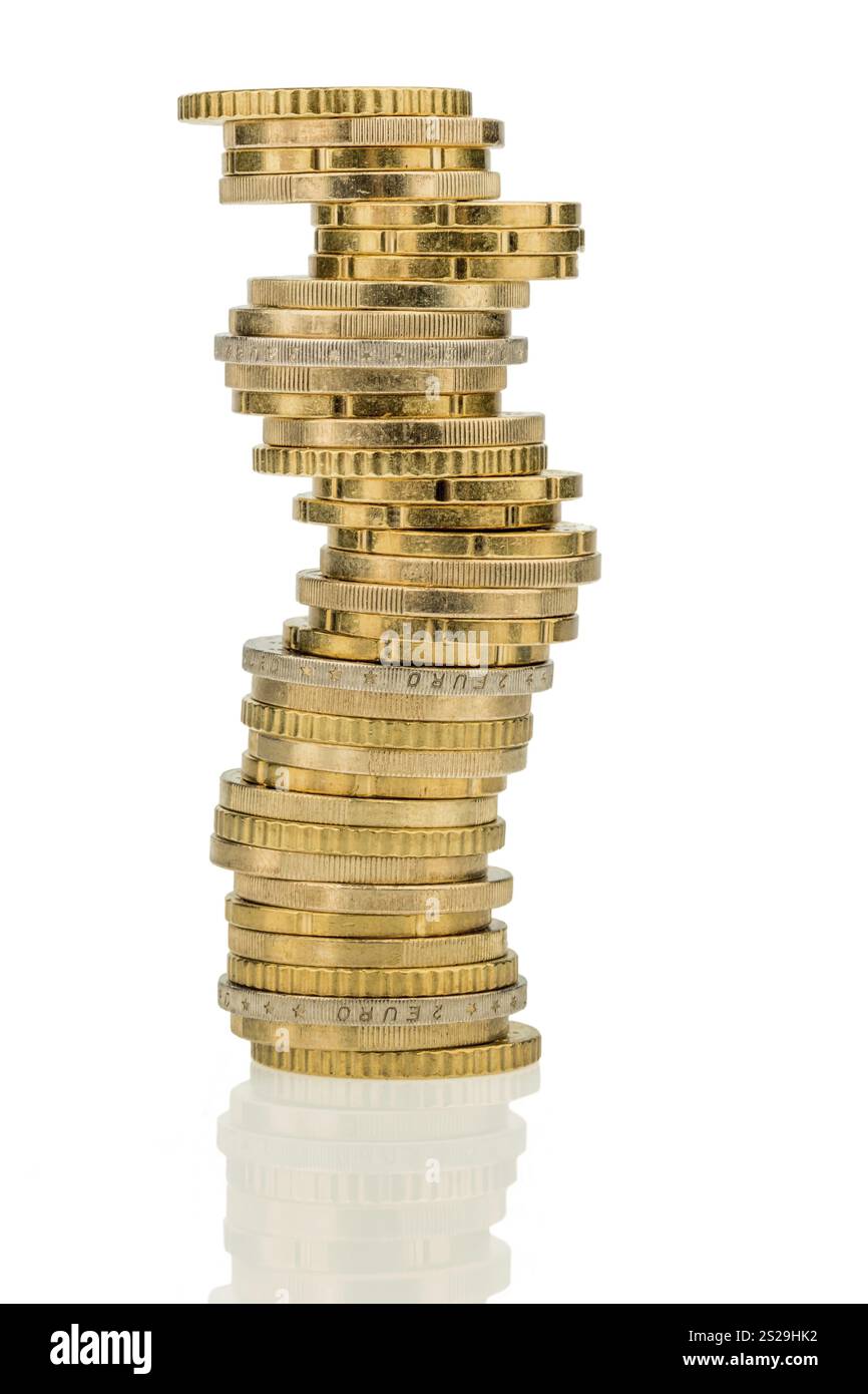 Una pila di monete davanti a uno sfondo bianco Foto Stock