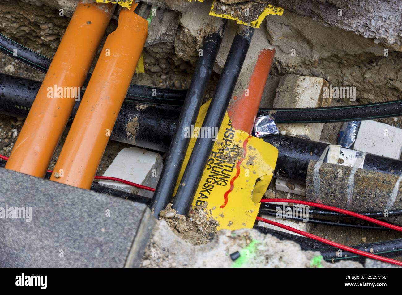 Nuovi tubi per l'acqua, il riscaldamento, il teleriscaldamento e l'elettricità sono in fase di posa in cantiere. Pozzo di scavo con linee di rifornimento Austria Foto Stock