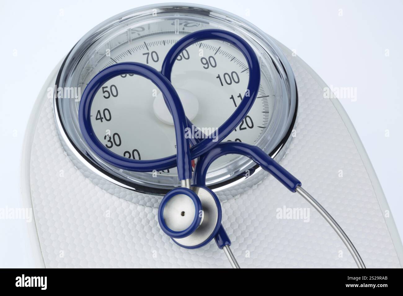Stetoscopio e scale, foto simbolica per peso, dieta e malattie cardiache Foto Stock