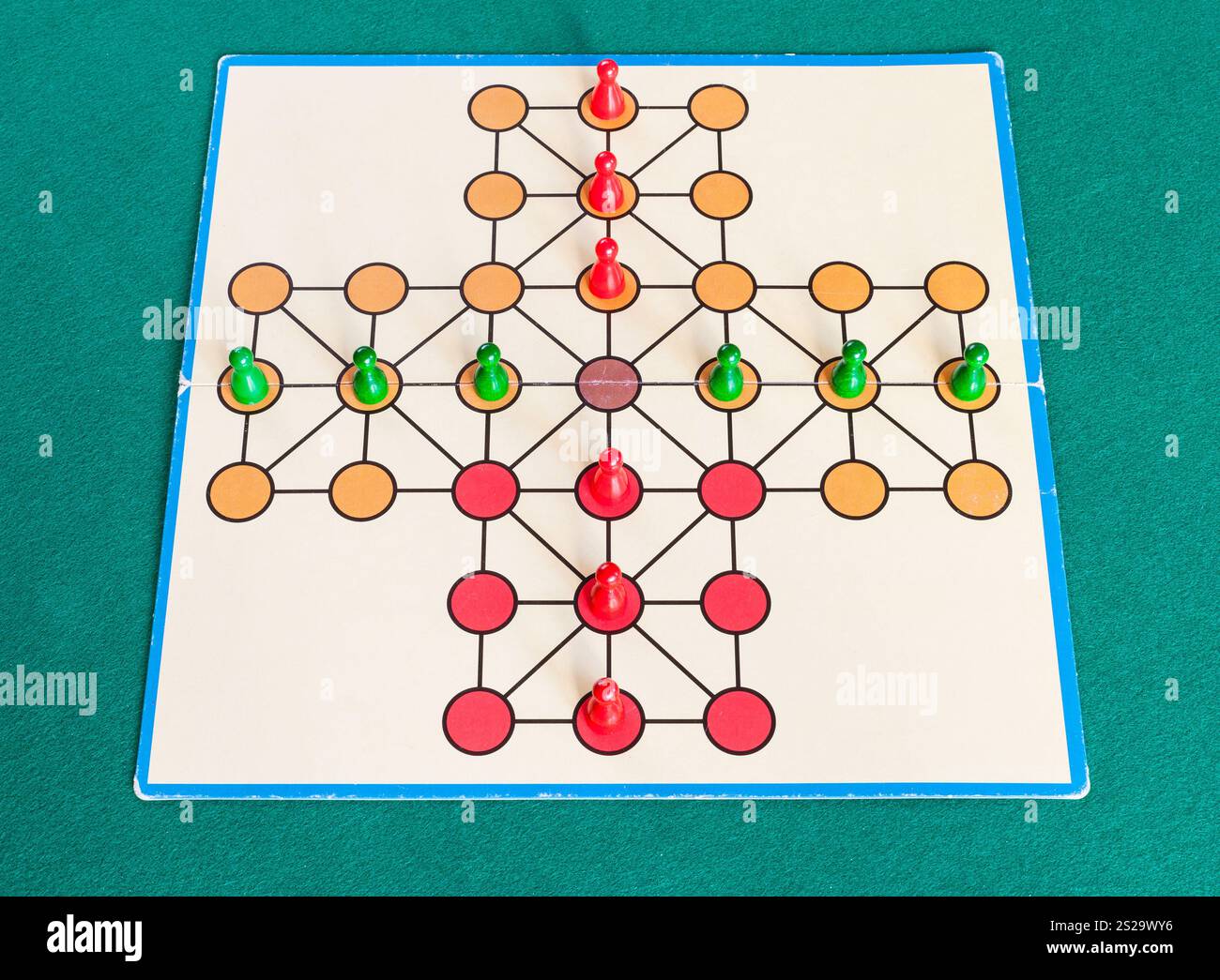 Setup della croce Solitario gioco di bordo sul verde baize tabella. La prima menzione di peg solitaire gioco possono essere identificati in Francia nel 1697 Foto Stock