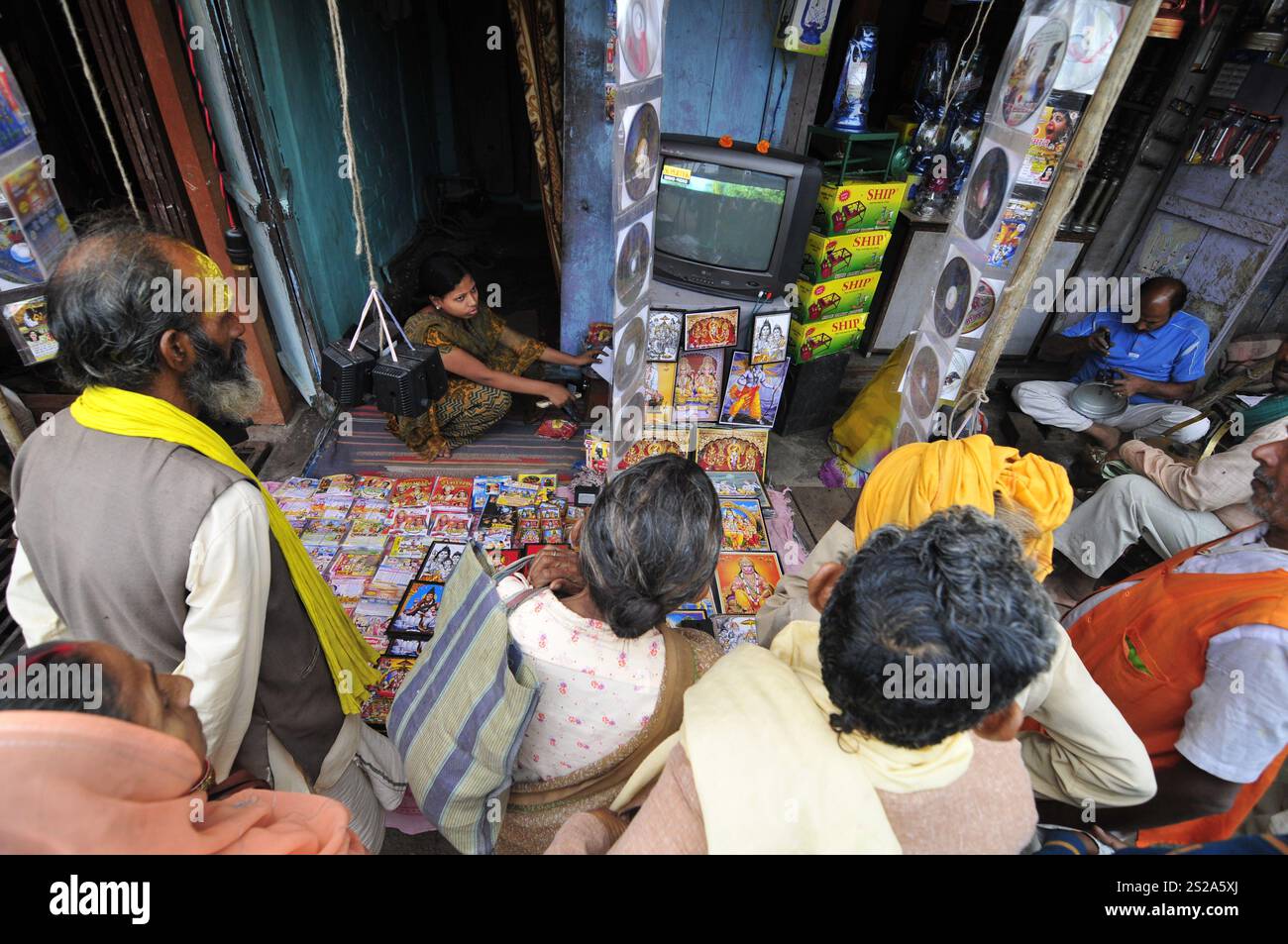 Uomini che guardano la TV fuori da un negozio ad Ayodhya, Uttar Pradesh, India. Foto Stock