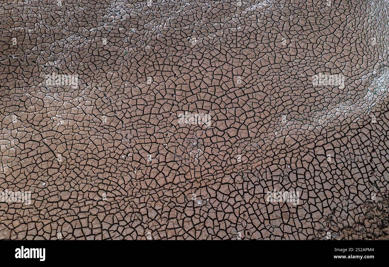 Letto di lago asciutto al tramonto, con fango incrinato sul fondo del lago, Foto Stock