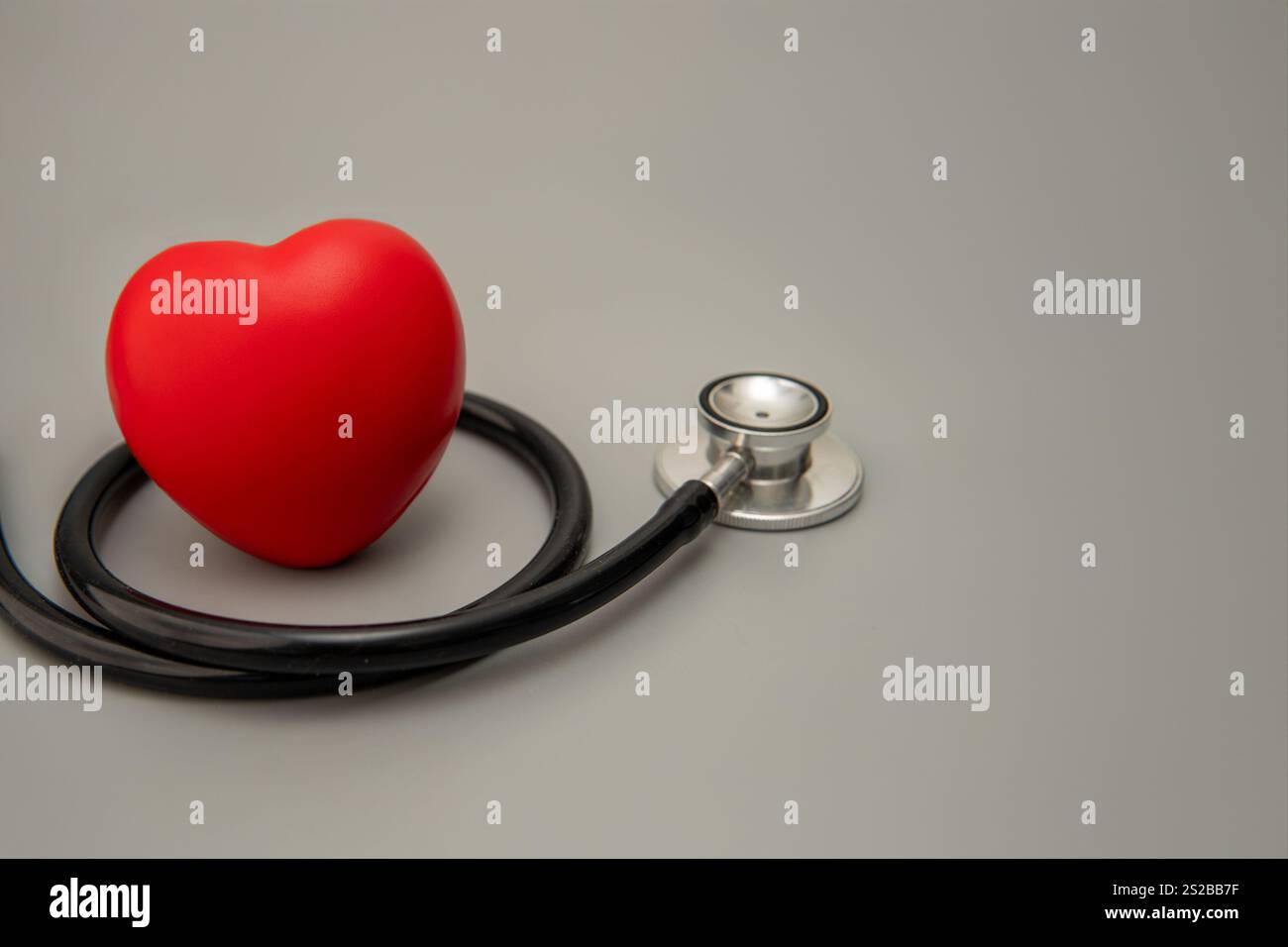 Un cuore rosso e uno stetoscopio. Copia spazio per il testo. Sanità, salute e salute cardiaca. Foto Stock