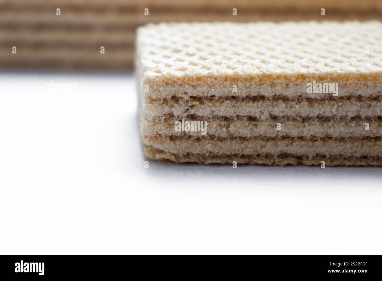 Due cialde croccanti con ripieno su uno sfondo bianco pulito, che mostrano la loro consistenza dorata e gli strati dolci Foto Stock